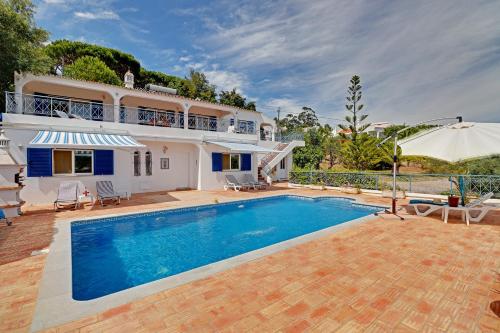 uma villa com piscina em frente a uma casa em Casa dos Sonhos by Portucasa em São Brás de Alportel