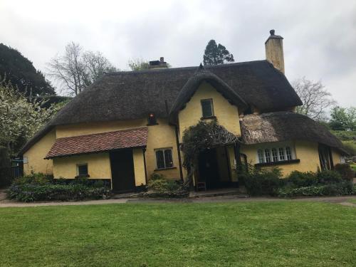 a large yellow house with a thatched roof at Cosy comfortable Slice of Heaven Annex in Porlock in Porlock