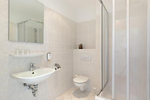 W łazience znajduje się umywalka, toaleta i prysznic. w obiekcie Novum Hotel City B Berlin Centrum w Berlinie