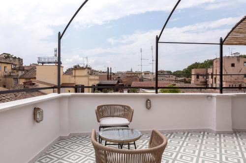 a balcony with chairs and a table on a roof at numa I Portico in Rome