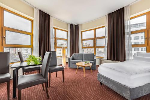 a hotel room with a bed and a couch and chairs at Novum Hotel City B Berlin Centrum in Berlin