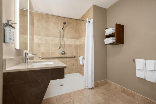 a bathroom with a shower and a sink at Staybridge Suites Oklahoma City-Quail Springs, an IHG Hotel in Oklahoma City