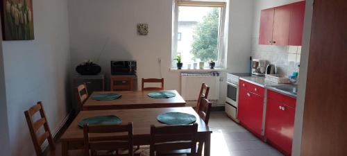 a kitchen with a table and chairs and a kitchen with red cabinets at Willa Anna in Rajcza