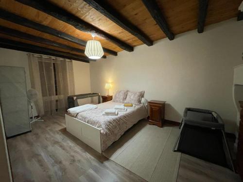 ein Schlafzimmer mit einem Bett in einem Zimmer mit Holzdecken in der Unterkunft Maison familiale en Périgord (Billard+Cheminée) 