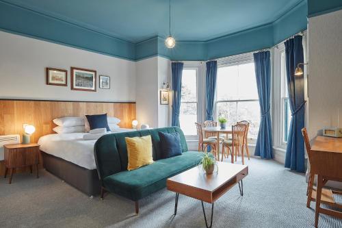 ノリッジにあるザ ジョージアン タウンハウスのベッド、ソファ、テーブルが備わるホテルルームです。
