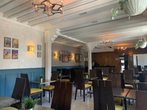 a dining room with tables and chairs and a chandelier at Royal Hotel Rabat in Rabat