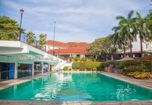 a swimming pool in front of a building at Cocoa Luxury Resort, Nyali, Mombasa in Mombasa
