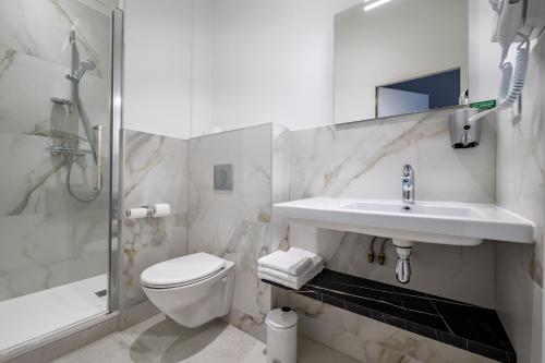 a bathroom with a toilet and a sink and a shower at Corner-Set Cholet Centre in Cholet
