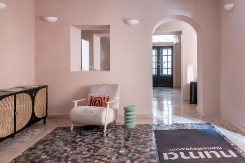 a living room with a chair and a rug at numa I Portico in Rome