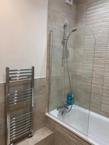 a bathroom with a shower with a bath tub at Cosy Beachfront Bournemouth 3-Bedroom 3-Bathroom Free Parking Free WiFi in Bournemouth