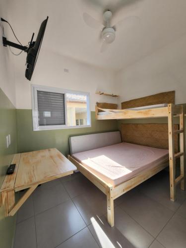 a room with two bunk beds and a window at CHALES DO BONA MARANDUBA in Ubatuba