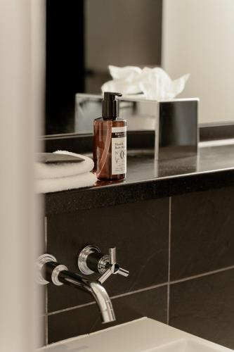 a bottle of soap sitting on a counter next to a sink at ABode Chester in Chester