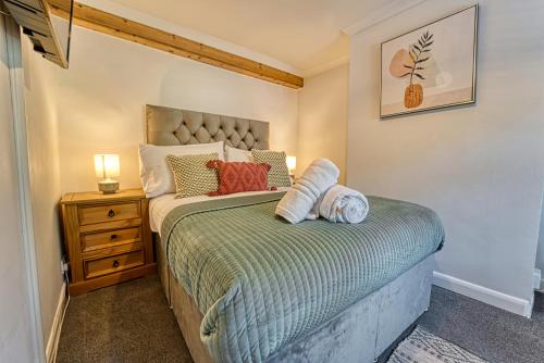 a small bedroom with a bed and a night stand at Guest Homes - London Road Cottage in Worcester