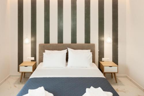 a bedroom with a bed with a striped wall at Mylos Mountain Villas- Villa Giorgio in Agios Nikitas