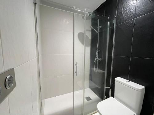 y baño con ducha de cristal y aseo. en Loft Ciudad Jardín N°2, en Córdoba