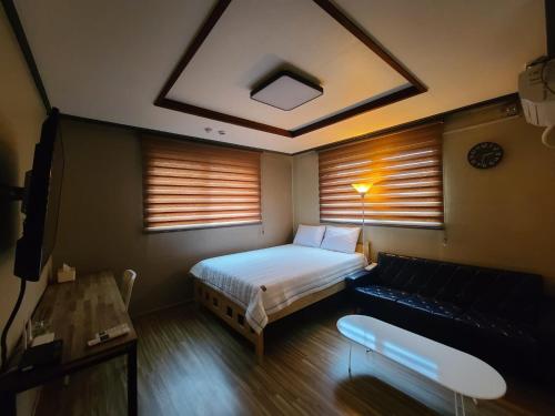 una piccola camera con letto e divano di TreehouseUnseo GuestHouse a Incheon