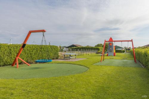 um parque com um parque infantil com um baloiço em Vakantiepark Zijpersluis em Burgerbrug