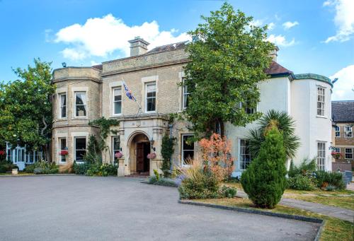 uma grande casa de pedra com uma grande entrada em Woodland Manor Hotel em Bedford