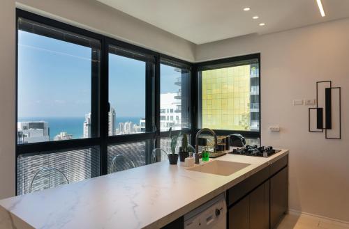 a kitchen with a large window with a view of the city at YalaRent sea-breeze penthouse with jacuzzi in Bat Yam