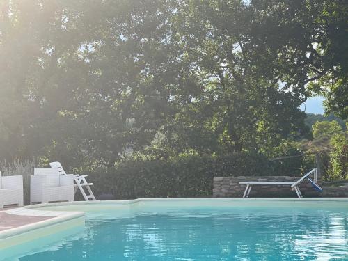 a swimming pool with two chairs and a table and a picnic table at Il Borghetto di Pedana- in Città di Castello