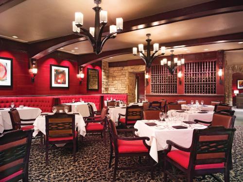 uma sala de jantar com mesas brancas e paredes vermelhas em Ameristar Casino Hotel em East Chicago