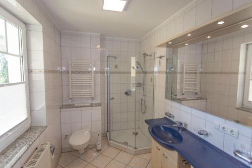 a bathroom with a sink and a shower and a toilet at Ferienhaus zum Südstrand in Ostseebad Sellin
