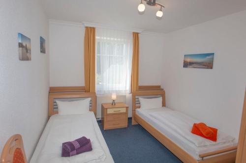 a room with two beds and a window at Ferienhaus zum Südstrand in Ostseebad Sellin