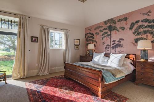 a bedroom with a large bed and a window at The Stables in Canterbury
