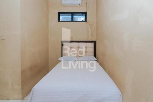 ein kleines Schlafzimmer mit einem Bett in einem Zimmer in der Unterkunft KORPRI Live House RedPartner 