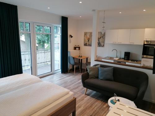 um quarto com uma cama, um sofá e uma cozinha em Gasthof Zumdohme em Lastrup