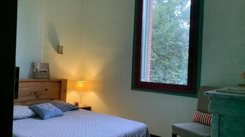 a bedroom with a bed and a window at Le Gite de Sébastien à Manyaques in Le Tech