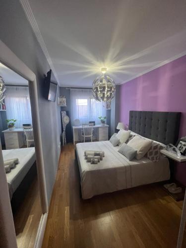 een slaapkamer met een groot bed en een paarse muur bij Habitación Bimba y Lolo in Ribadumia