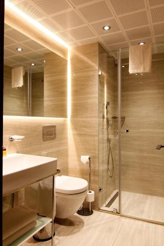 a bathroom with a toilet and a glass shower at Sogut Hotel Old City in Istanbul