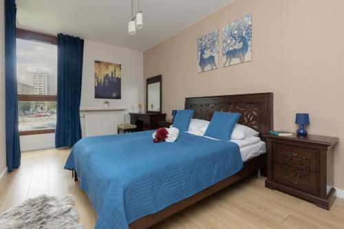 ein Schlafzimmer mit einem blauen Bett und einer blauen Decke in der Unterkunft Chłodna Apartment European Square Warsaw by Renters in Warschau