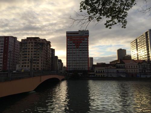 eine Brücke über einen Fluss in einer Stadt mit hohen Gebäuden in der Unterkunft Rede Andrade Plaza Recife in Recife
