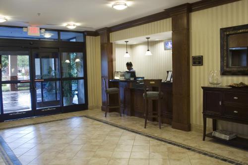 a lobby with a woman sitting at a desk in a hotel at Staybridge Suites Memphis-Poplar Ave East by IHG in Memphis