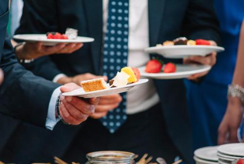 a group of people holding plates of desserts at Hotel Kronprinz Berlin in Berlin
