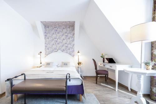 a bedroom with a bed and a desk and a chair at Hotel Kronprinz Berlin in Berlin