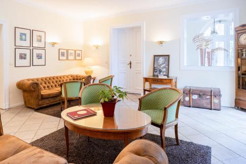 a living room with a couch and a table and chairs at Hotel Kronprinz Berlin in Berlin