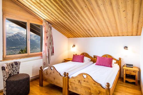 a bedroom with a bed with a wooden ceiling at Hôtel Magrappé in Veysonnaz