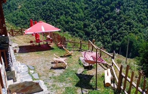 a patio with a pink umbrella and a table and chairs at Qaldea Resort in Ushguli