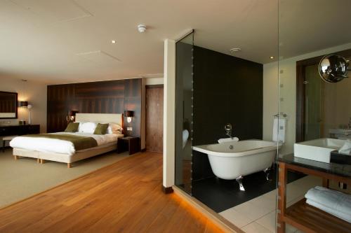 a bathroom with a bed and a tub in a room at ABode Chester in Chester