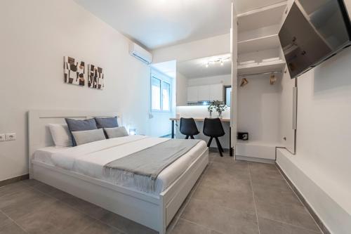 a bedroom with a large bed and a kitchen at Phaedrus Living: City Center Executive Flat Stadiou in Athens
