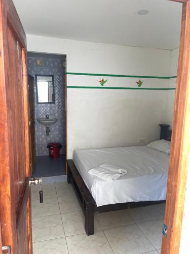 a small bedroom with a bed and a sink at Palomino Hostel in Palomino