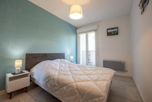 a bedroom with a white bed and a window at Vacances a deux pas de la plage pour quatre personnes in Plage-des-Demoiselles
