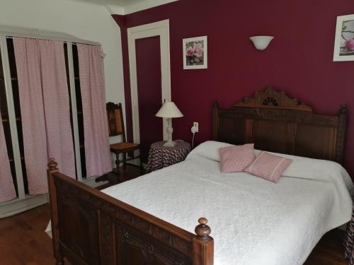 a bedroom with a bed with pink pillows on it at Maison de Campagne en Centre Finistère in Hinguer