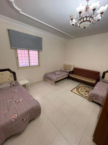 a large room with two beds and a chandelier at شقة الشرقي 1 in Abha