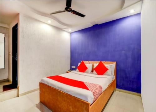 a bedroom with a bed and a blue wall at Hotel Sangam in Ahmedabad
