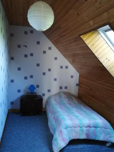 a bedroom with a bed and a wooden ceiling at Maison de Campagne en Centre Finistère in Hinguer