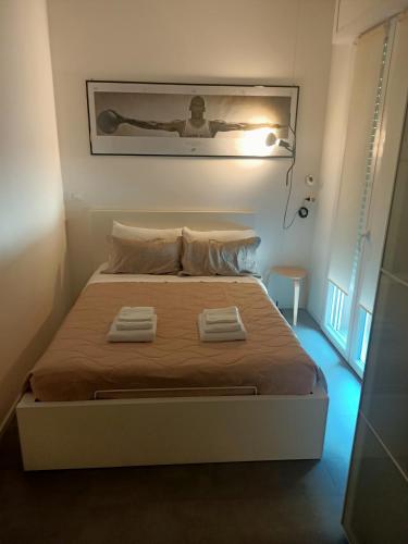 sypialnia z łóżkiem i dwoma ręcznikami na nim w obiekcie Bologna House Residence w Bolonii